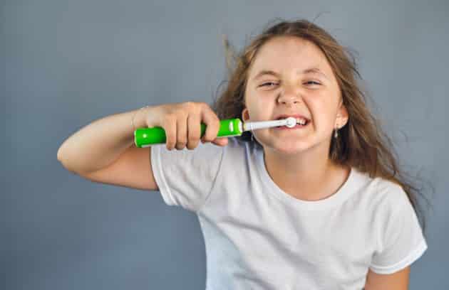 kid girl brushing her teeth