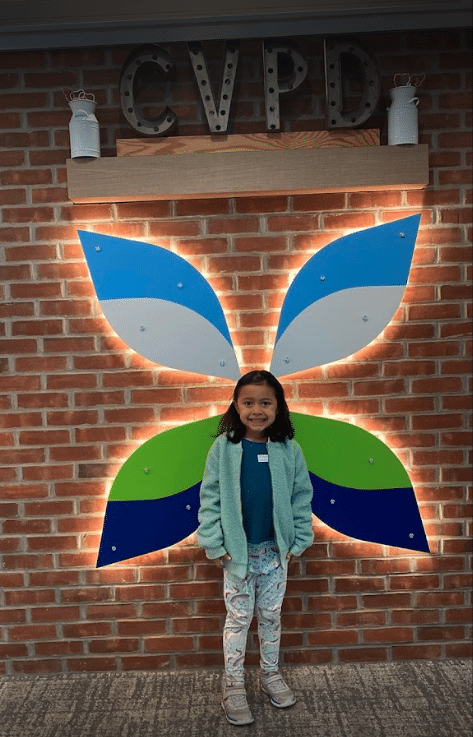 a girl in front of the CVPD logo