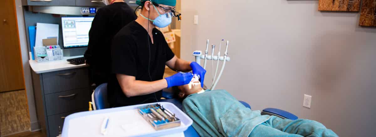 A pediatric dentist examining a young patient during a routine dental exam