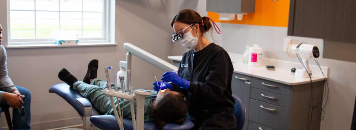 Pediatric dental hygienist taking care of a young patient