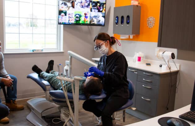 Pediatric dental hygienist taking care of a young patient