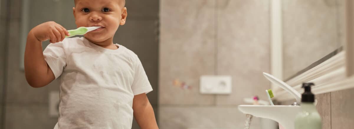 Photo of a cute toddler boy brushing teeth in the bathroom